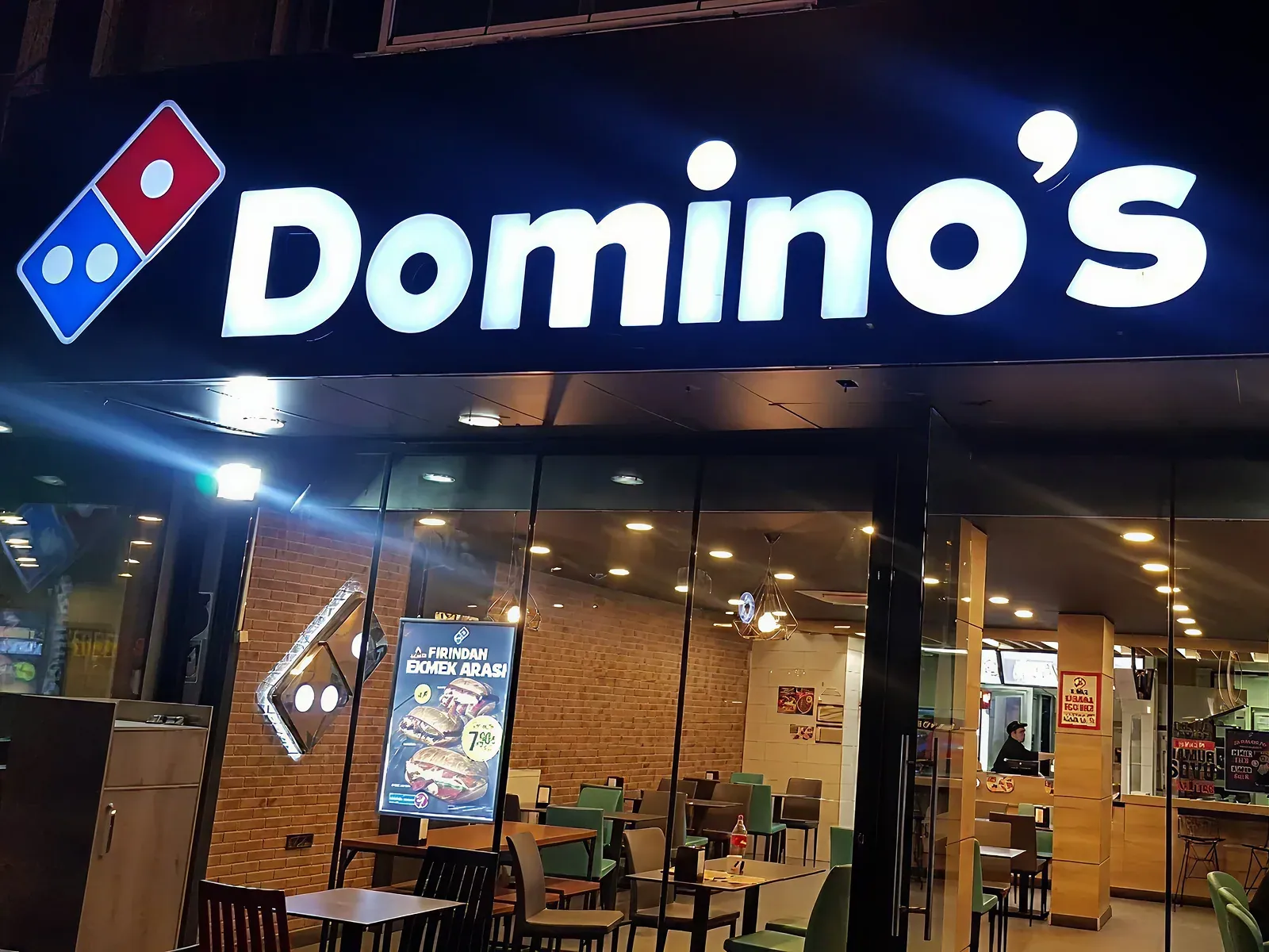 A Domino's storefront lit up at night