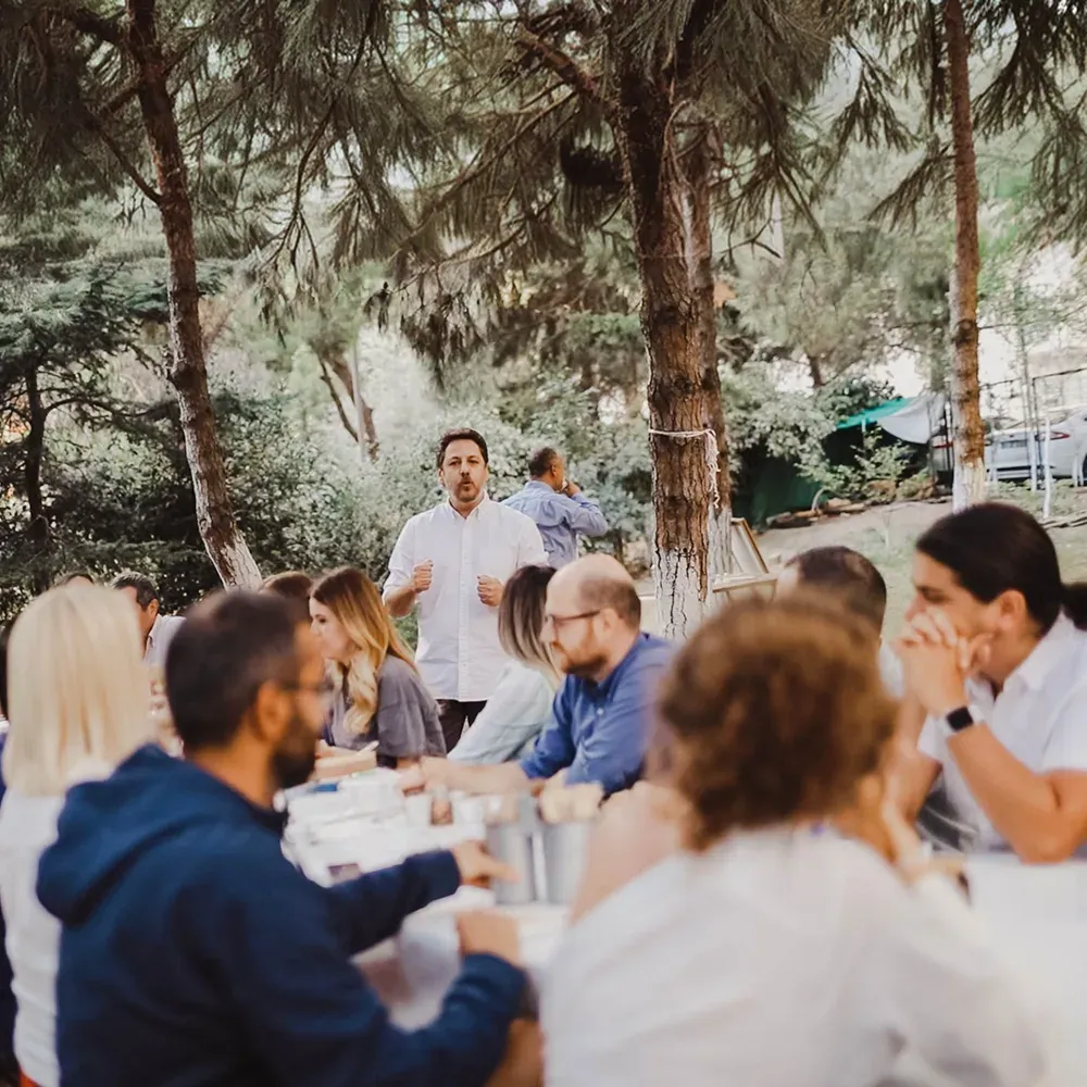 The OmmaWorks team gathered around a long table outdoors