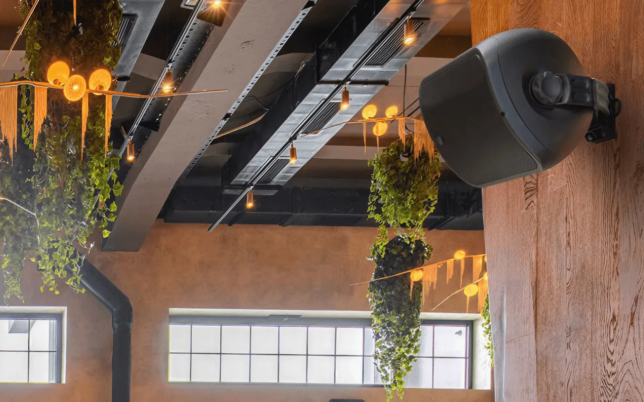 A ceiling-mounted in-store speaker in a café interior